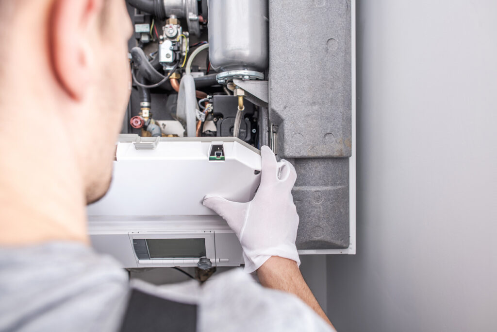 A technician repairing a furnace